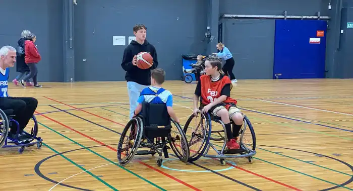 Two young wheelchair basketballers face off during tip off.